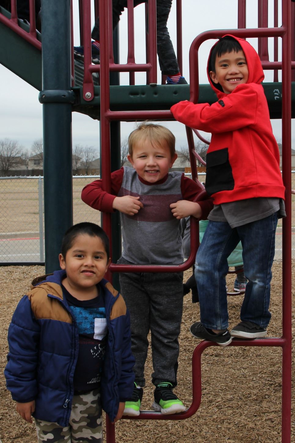 photo of three male BES students on playground